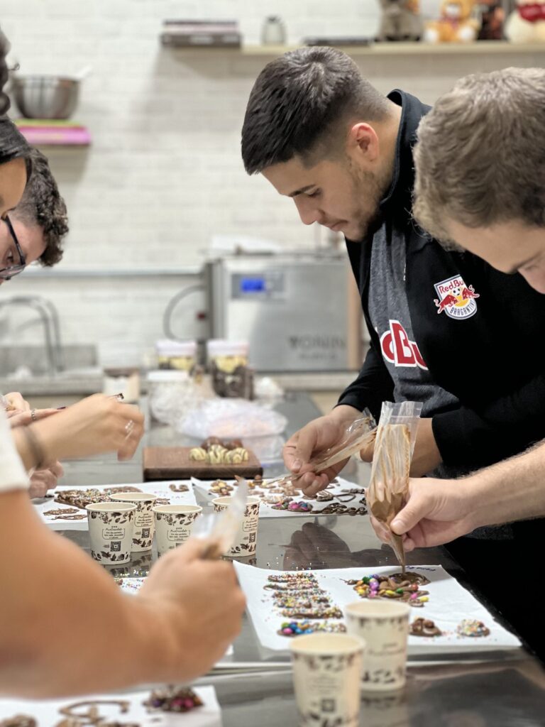 Participantes decorando seus chocolates na etapa mão na massa